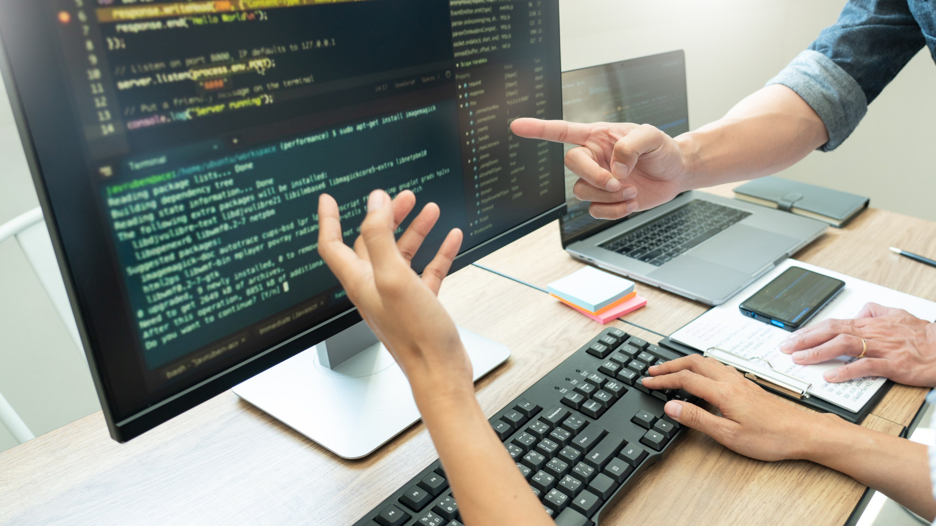 hands in front of a display and keyboard